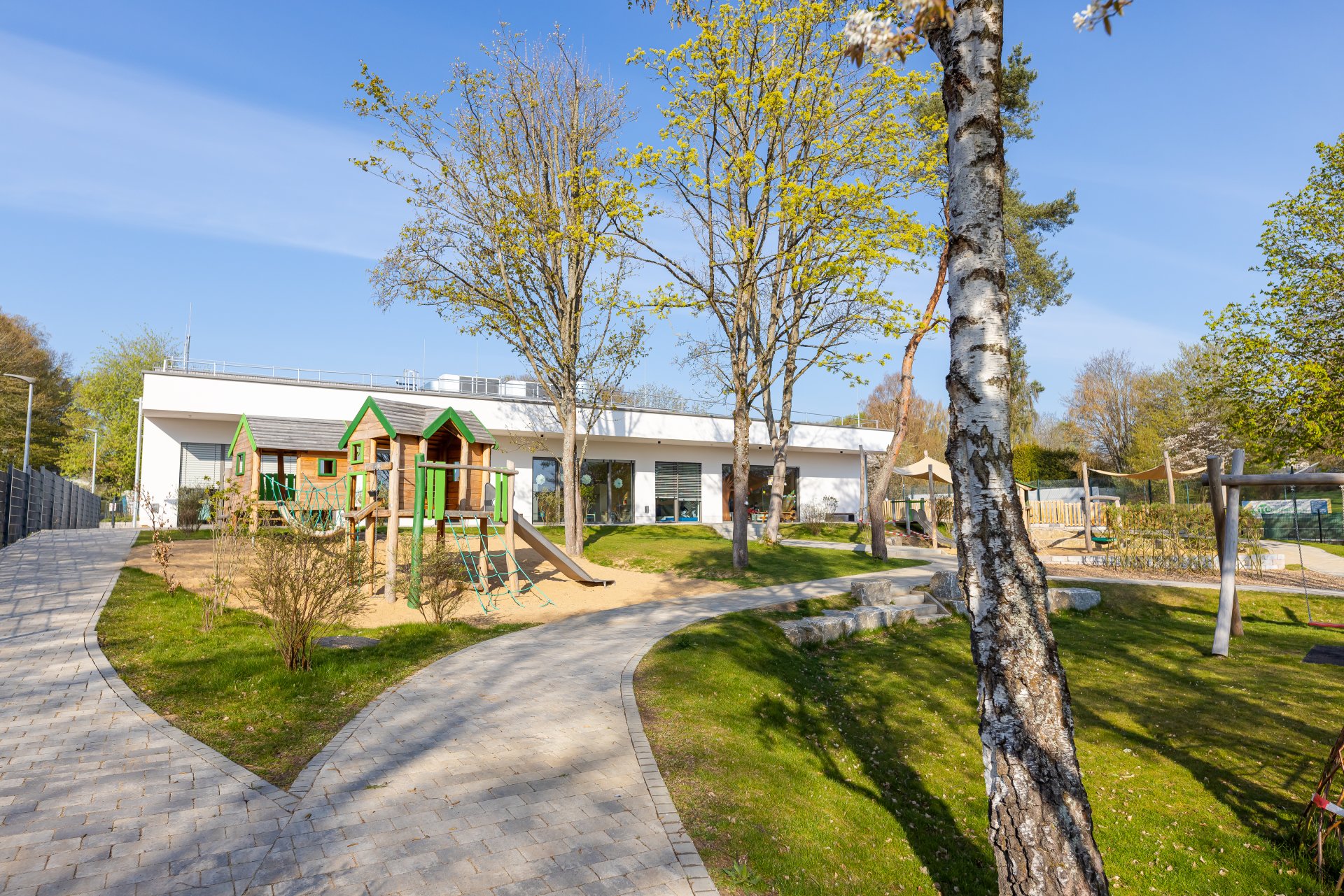 Außenbereich der Kindertagesstätte Dreikäsehoch in Rheinböllen mit Schaukel, Rutsche und Sandkasten